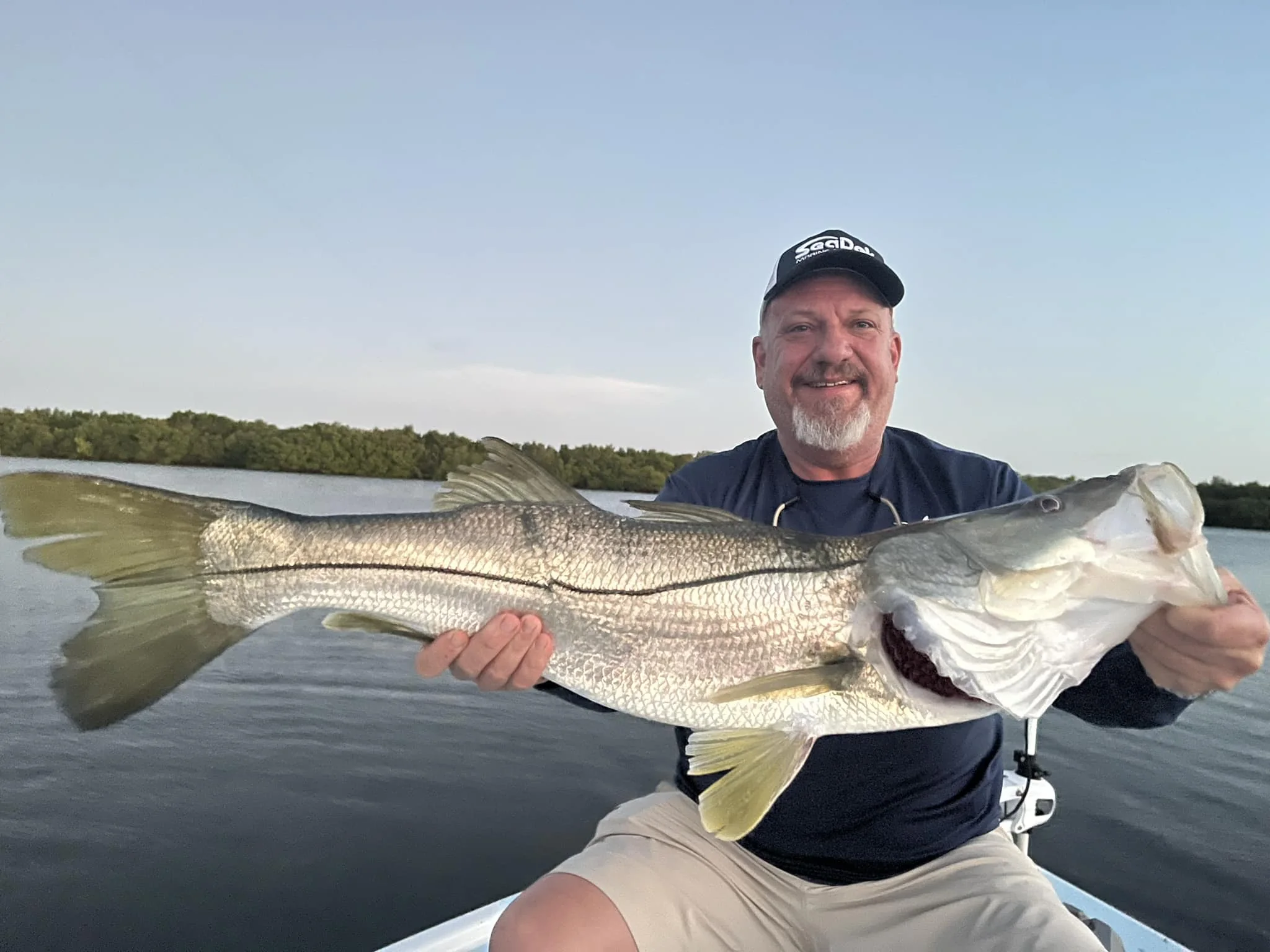 Man Snook Fishing in Fort Pierce holding a large Snook. 