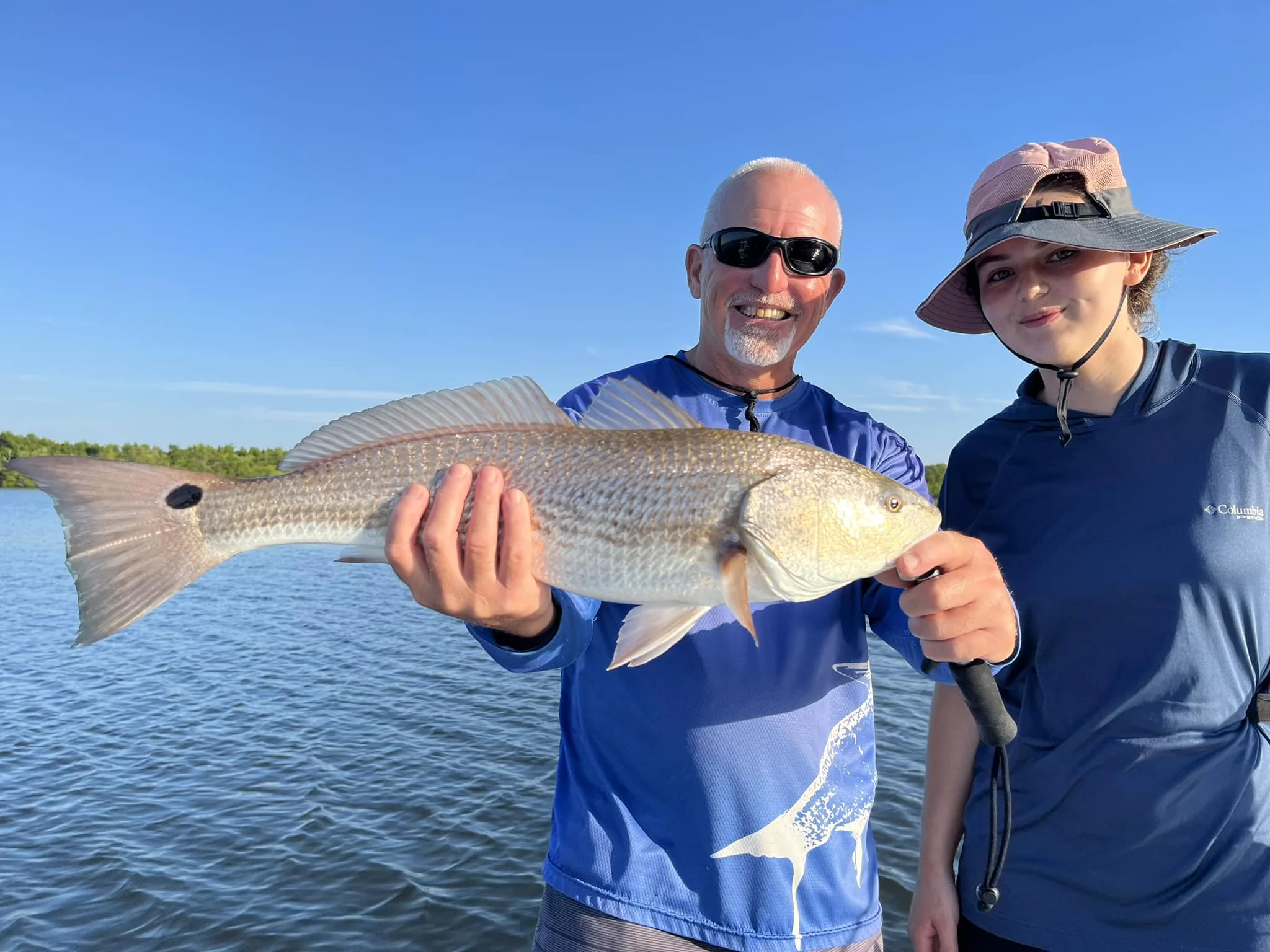 Family with man holding a Redfish in Fort Pierce